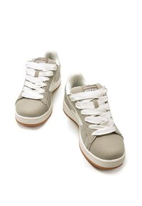Scarpe sportive beige in tessuto con lacci bianchi e suola in gomma. Presentano un interno imbottito e un logo del marchio sulla linguetta.