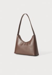 Borsa a spalla in pelle marrone con una silhouette curvata, tracolla singola e chiusura con zip. Presenta una texture liscia e un design minimalista.