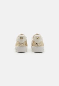 Witte sneakers met een gestructureerd gouden netpaneel bij de hiel, voorzien van een gouden logo en een gladden synthetisch materiaal. Vlakke rubberen zool.