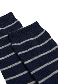 Calcetines azul marino con rayas horizontales blancas. Fabricados con un material suave, presentan puños acanalados y una textura lisa.