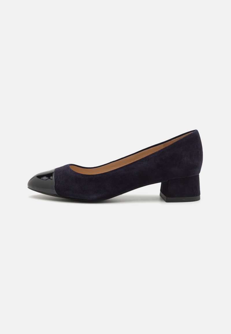 Blue suede pump with a patent leather cap toe, low block heel, and a rounded shape. Smooth texture with a contrasting shiny accent.