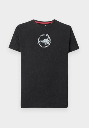 Svart t-skjorte med korte ermer, med en sirkulær hvit skorpiongrafikk og teksten «Alpha Industries 1959 Tennessee U.S.A.» på brystet.