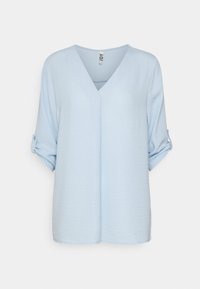 Blusa azzurro chiaro, dalla vestibilità ampia, con scollatura a V e maniche arrotolate fissate da patte con bottoni, esposta su uno sfondo bianco.
