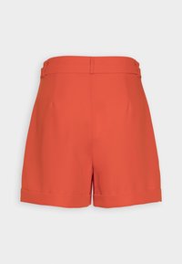 Pantaloni shorts rossi su misura con una texture liscia, caratterizzati da un semplice orlo a risvolto, una vita nascosta e un taglio classico, mostrati da dietro.