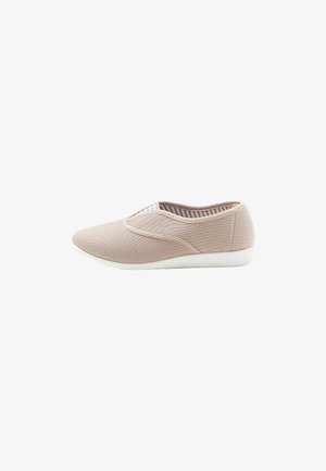 Zapato slip-on de tela beige con un upper texturizado, paneles laterales elásticos y una suela de goma blanca. El interior presenta un forro a rayas.