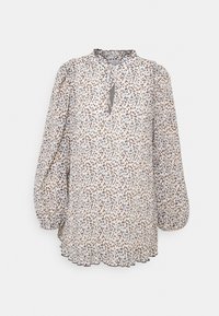 Blouse à manches longues avec petites taches abstraites bleues et marron, col volanté, encolure goutte avec lien et ourlet légèrement évasé.