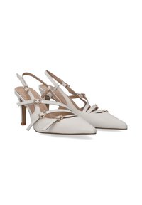Białe skórzane czółenka na obcasie typu slingback z ostrymi noskami, z krzyżującymi się paskami i metalowymi klamrami, oraz 6 cm obcasem typu stiletto.