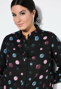 Svart skjorta med ett smyckesmönster i rosa, blått och grönt. Knapp-up design med klassisk krage och mjuk textur.