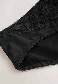 Black underwear featuring a textured lace waistband, smooth fabric, and a delicate trim along the edges, emphasizing intricate detailing.