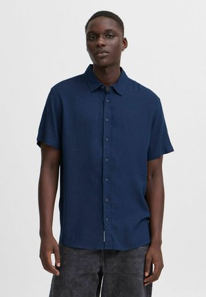 Navy short-sleeve button-up shirt with a collar, made of lightweight fabric, featuring a button placket and a slightly curved hem.