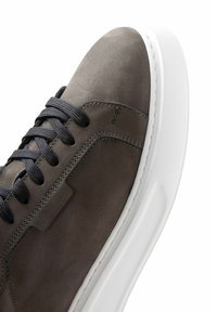 Sneaker grigio in suede con punta tondeggiante, lacci neri, suola in gomma bianca e dettagli di cucitura minima sulla parte superiore.