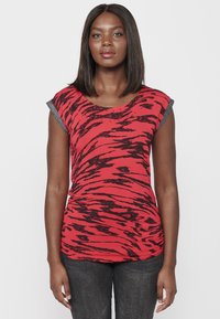 T-shirt rouge avec un motif rayé noir de tigre, manches courtes avec des accents gris, design ajusté et texture de tissu douce.