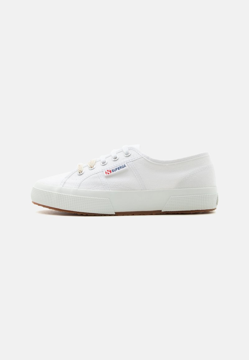 Λευκό χαμηλό καμβά sneaker με λαστιχένια σόλα, μεταλλικά ρούχα και ετικέτα με το λογότυπο "Superga" στην πλευρά, εμφανιζόμενο από την εξωτερική πλευρά.
