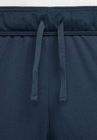 Tamsiai mėlynos sportinės šortai su tekstūruota juosmens juosta su raišteliais ir lygia kūno medžiaga, sukurti patogumui ir judrumui.