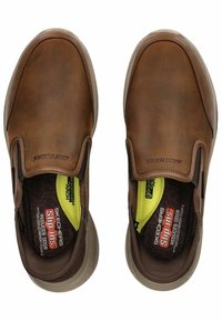 Braune Leder-Slipper mit glatter Oberfläche, elastischen seitlichen Akzenten und gepolsterten Einlegesohlen mit einer gelben Schaumstoffeinlage für zusätzlichen Komfort.