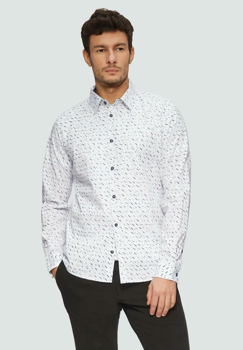 Witte overhemd met een blauw abstract patroon, lange mouwen en een kraag. Voorzien van knopen aan de voorkant en een ontspannen pasvorm.