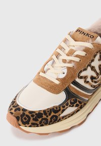 Sneaker con una palette di colori crema e marrone, caratterizzato da suede con stampa leopardata, dettagli testurizzati e strisce nere a contrasto. Dettaglio in morbido pelo.