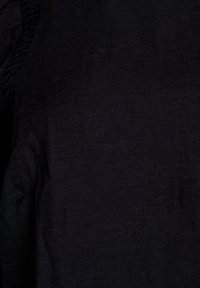 Black fabric with a subtle texture and a smooth finish. Features gathered detailing along the edge, creating a soft, flowing appearance.