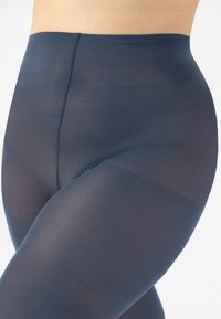 Collant navy trasparenti con una finitura liscia e opaca. Design a vita alta e bordi senza cuciture per migliorare il comfort e la vestibilità. Pannelli leggermente testurizzati visibili.