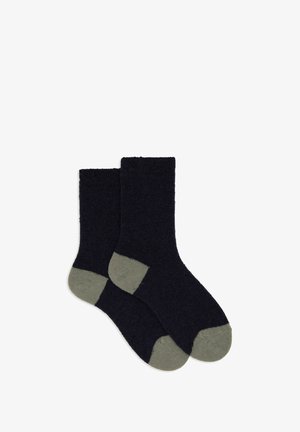 Calzini blu navy con una trama morbida e dettagli in verde oliva sulla punta e sul tallone, con polsino a costine per maggiore comfort e aderenza.