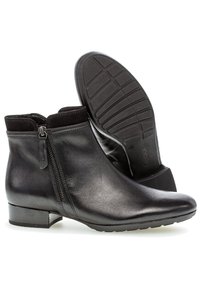 Schwarze Leder-Ankleboots mit glatter Oberfläche, seitlichem Reißverschluss, weichem Textilkragen, niedrigem Blockabsatz und strukturiertem Gummisohle für besseren Halt.