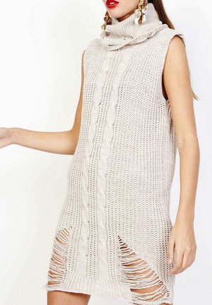 Vestido sin mangas de punto beige con cuello alto, diseño de trenzas, aberturas laterales con bordes deshilachados y un acabado texturizado.