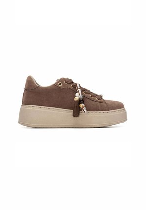 Zapatilla de plataforma de ante marrón con suela beige gruesa y accesorio decorativo de cordones con cuentas sobre fondo blanco.