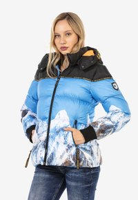 Isolierte Pufferjacke mit blauem Körper und Bergdruck, schwarzen Schultern, Reißverschluss und gerippten Bündchen. Mit Kapuze.
