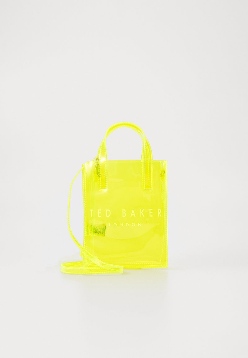 Kirkas keltainen mini-tote-laukku, jossa on kaksinkertaiset kahvat ja irrotettava olkahihna. Etupuolella on logo ja laukku on sileäpintainen.