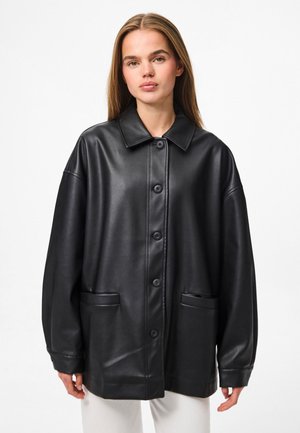 Sort eksklusiv læder oversized jakke med nedfoldet krave, frontlukning med knapper og to klaplommer. Glat tekstur med en afslappet pasform.
