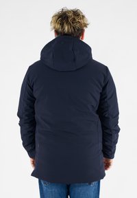Mørkeblå isoleret jakke med en stor h�ætte, glat tekstur og tætsiddende manchetter. Har en længere bagende og minimal brandingdetalje.