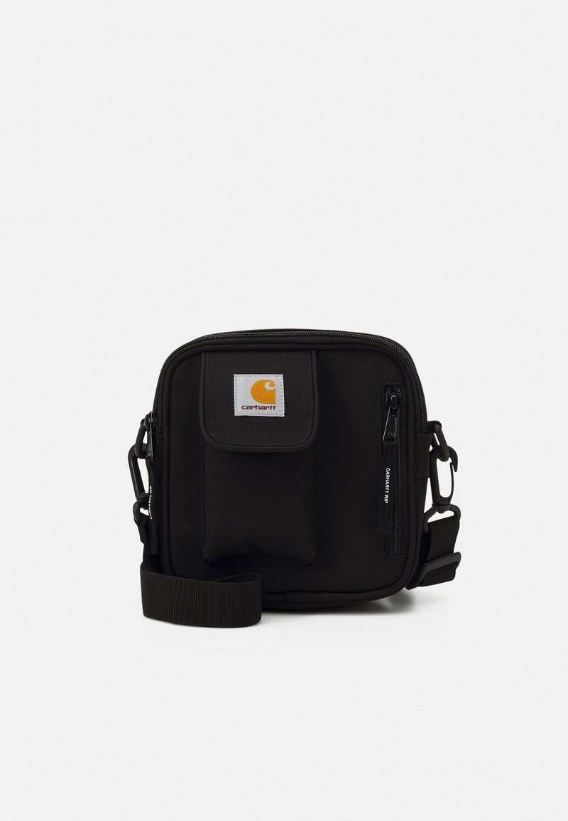 Czarna torba crossbody z płótna z przednią kieszenią, wyraźnym logo Carhartt, zapięciem na zamek i regulowanym paskiem. Solidna konstrukcja w minimalistycznym stylu.