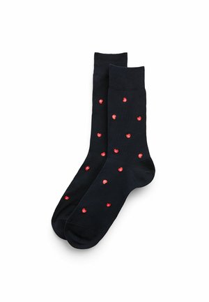 Dunkelblaue Socken mit einem Muster aus kleinen roten Herzen auf der Oberfläche. Hergestellt aus weichem, dehnbarem Stoff mit einem gerippten Bündchen.