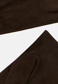Bruna mockaskinnhandskar med mjuk textur, avsmalnande design och sydda detaljer längs handleden och fingrarna. Inga synliga detaljer i metall.
