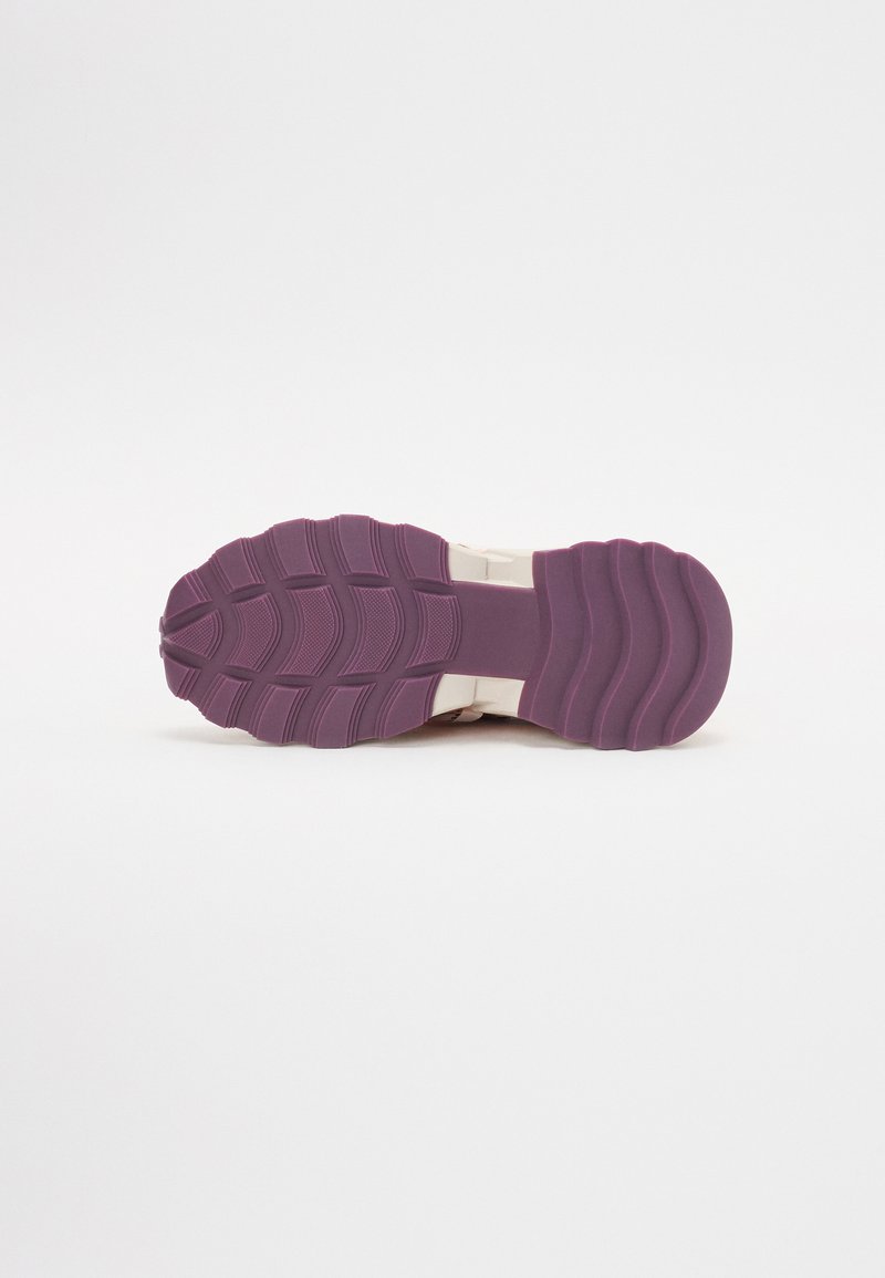 Suola della scarpa con un design testurizzato, caratterizzata da una base in gomma viola e scanalature, che migliorano la presa e la durabilità. Sfondo bianco pulito.