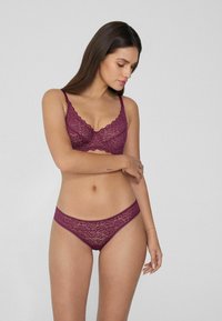 Bralette en dentelle et string assorti en bourgogne profond. Bords festonnés sur le soutien-gorge, motif en dentelle florale, fines bretelles réglables.
