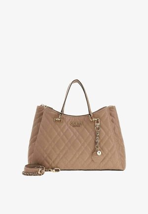 Sac à main beige matelassé avec deux poignées, ferrures dorées et une bandoulière amovible. Comprend une plaque avec logo et un pendentif décoratif.