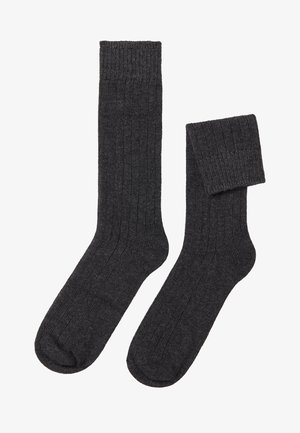 Dunkelgraue gerippte Socken mit weichem Material und elastischem Bund, die ein einheitliches Webmuster und abgerundete Zehen aufweisen.