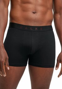 Boxers en coton noir avec le logo FALKE sur la ceinture élastique. Présente un design ajusté et une texture lisse.