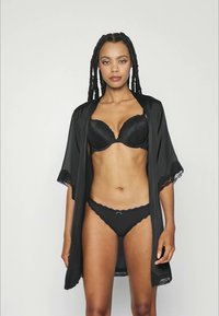 Robe de renda preta sobre um sutiã e calcinhas acolchoados pretos. O robe apresenta mangas curtas e rendas, criando um visual delicado.