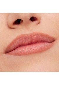 Nærbilde av lepper med en glatt, matt finish i en myk nude-rosafarge. Teksturen ser myk ut med naturlige konturer og subtil definisjon.