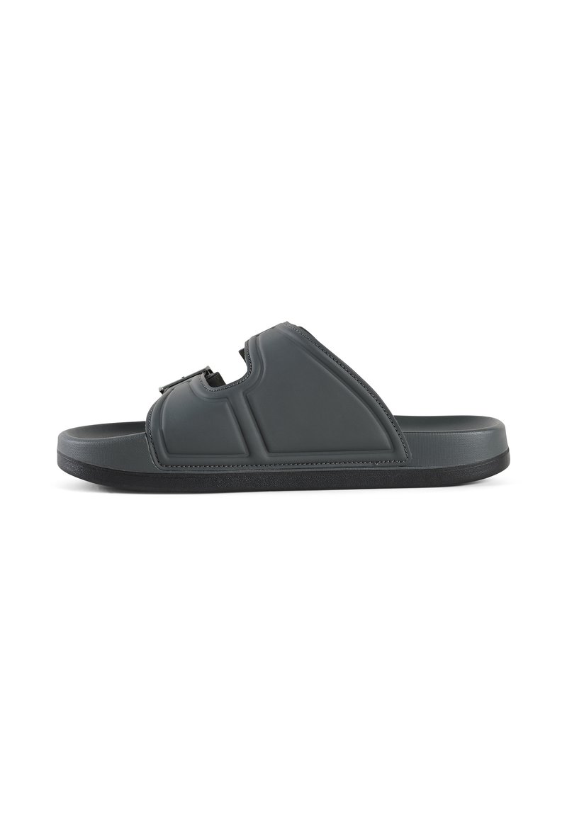Donkergrijze slip-on sandaal van zacht plastic. Voorzien van een enkele verstelbare band en een getextureerde zool voor grip. Gecenterde vorm met padding.