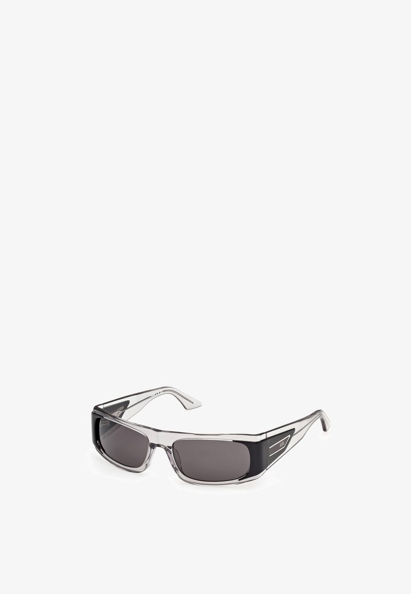 Gafas de sol rectangulares con lentes oscuras y montura gris transparente con detalles negros en las patillas y varillas.