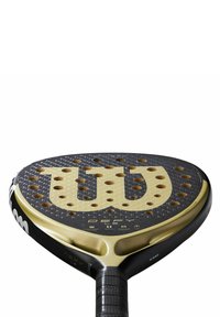 Padel racket met een zwart en gouden ontwerp, voorzien van een gestructureerd oppervlak, grote perforaties voor grip, en een onderkant met een rubberen handvat.