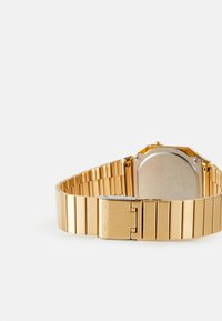 Orologio Casio color oro con cassa rettangolare, bracciale a maglie metalliche, superficie liscia e chiusura incisa con il nome del marchio.