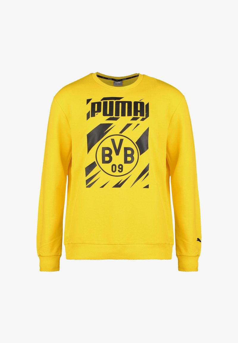 Żółta bluza z bawełny z czarnymi grafikami. Posiada okrągły dekolt, długie rękawy oraz ściągacze na rękawach i u dołu. Obecne logo i szczegóły drużyny.