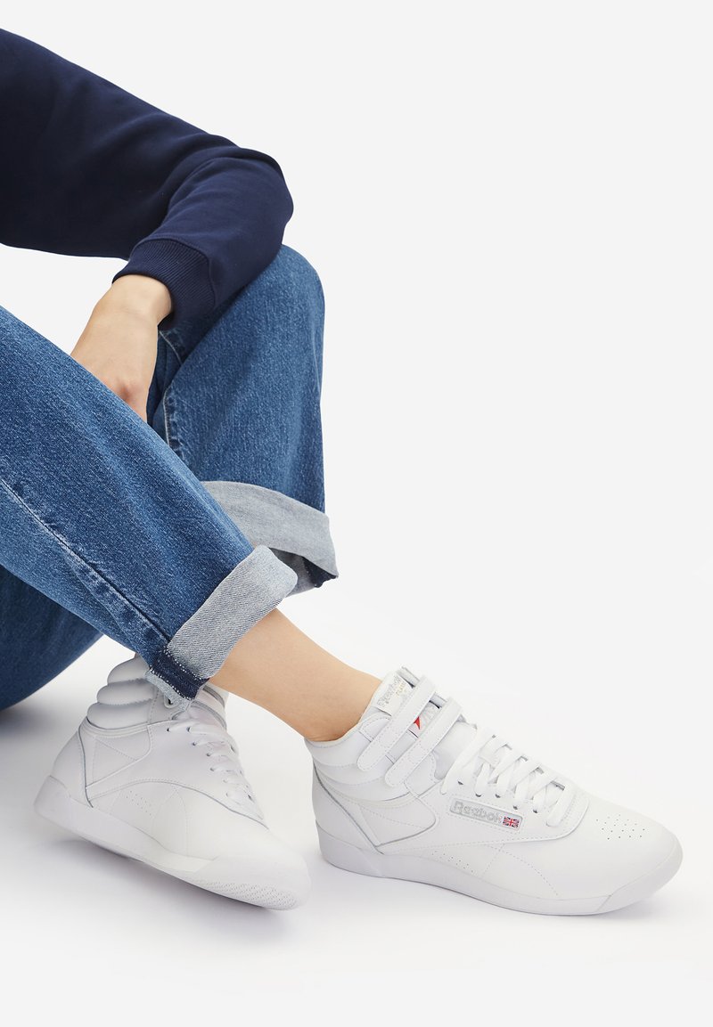 Kerged valged tossud siledast nahast, seotud ja olnud takjapaelaga, augud varvaste juures ja peened brändi aktsendid. Kandsid rullitud teksapükse.