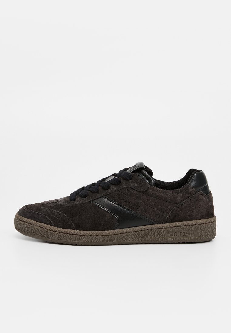 Sneakers en suede gris foncé avec des accents en cuir noir, bout rond et design à lacets. Équipés d'une semelle en caoutchouc texturée. Éléments de design simples.