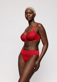 Rood kanten beha en bijpassende slip met bloemmotieven, verstelbare bandjes en een gladde tailleband.