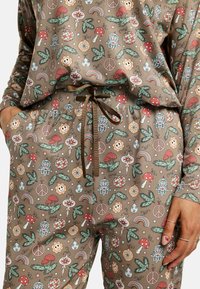 Hnedé vzorované pohodlné oblečenie s motívmi húb, kvetín, symbolov mieru a dúh. Obsahuje pás so šnúrkou a bočné vrecká.